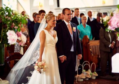 Brautpaar steht während der Trauung vor den Gästen, die Braut mit langem Schleier – Hochzeit in Hamburg