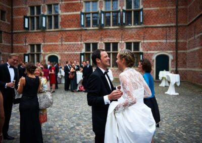 Brautpaar empfängt die Gäste vor einem Backsteinschloss – Hochzeit in Hamburg