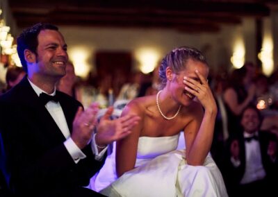 Braut lacht mit der Hand vor dem Gesicht beim Hochzeitsessen, neben ihr der Bräutigam – Hochzeit in Hamburg