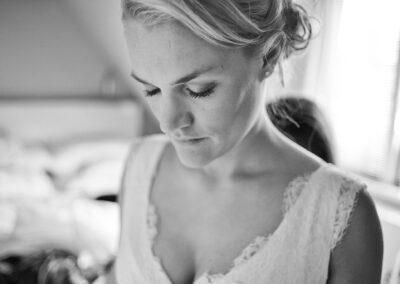 Braut blickt beim Getting Ready gedankenverloren nach unten, schwarzweiß – Hochzeit in Hamburg