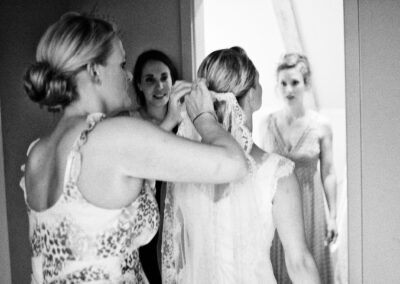 Braut umarmt beim Getting Ready gerührt eine Freundin, schwarzweiß – Hochzeit in Hamburg