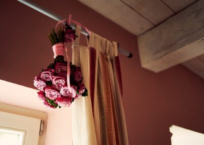 Brautstrauß aus Rosen hängt in einem rosa Zimmer am Fenster – Hochzeit in Hamburg