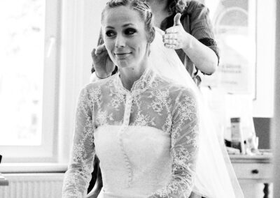 Braut wird beim Getting Ready frisiert, schwarzweiß – Hochzeit in Hamburg