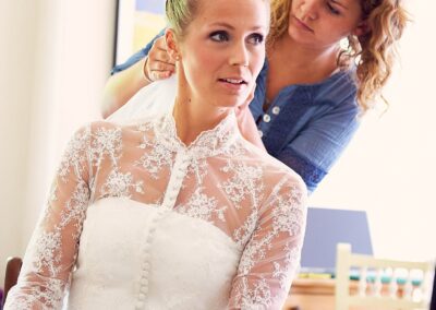 Braut im Spitzenkleid wird beim Getting Ready frisiert – Hochzeit in Hamburg
