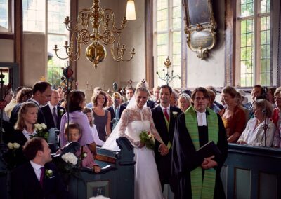 Volle Dorfkirche bei der Trauung, der Pastor im grünen Talar – Hochzeit in Hamburg
