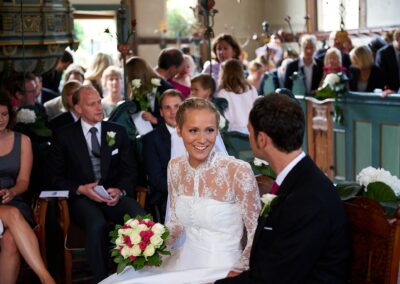 Lächelnde Braut mit Brautstrauß während der Trauung in der Kirche – Hochzeit in Hamburg