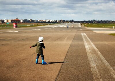 Kind auf Inlineskates auf der Landebahn eines ehemaligen Flugfelds
