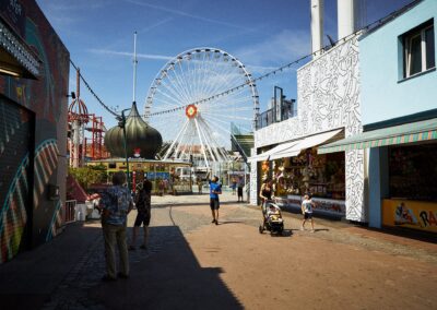 Vergnügungspark mit Riesenrad und Buden an einem sonnigen Tag