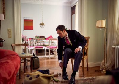 Bräutigam bindet sich im Wohnzimmer die Schuhe – Hochzeit in Hamburg